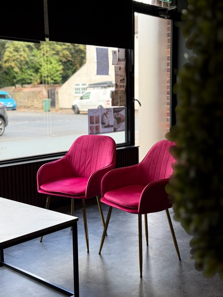 Looking out from inside the studio towards the street, with magenta velvet seating in the foreground.